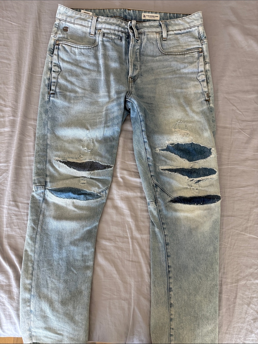 Men's Light Wash Distressed Jeans with Dark Patch Details